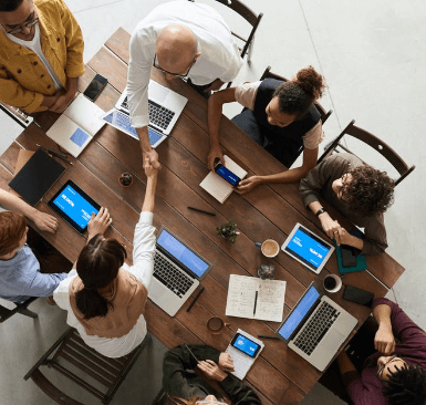 A top view of people around a table on laptops