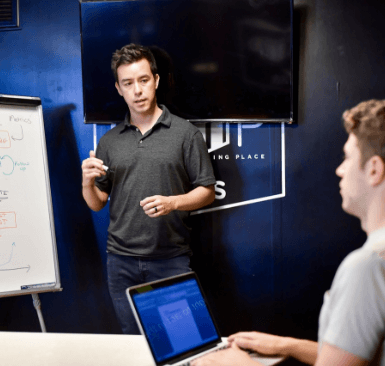 A man standing in front of another person presenting to them